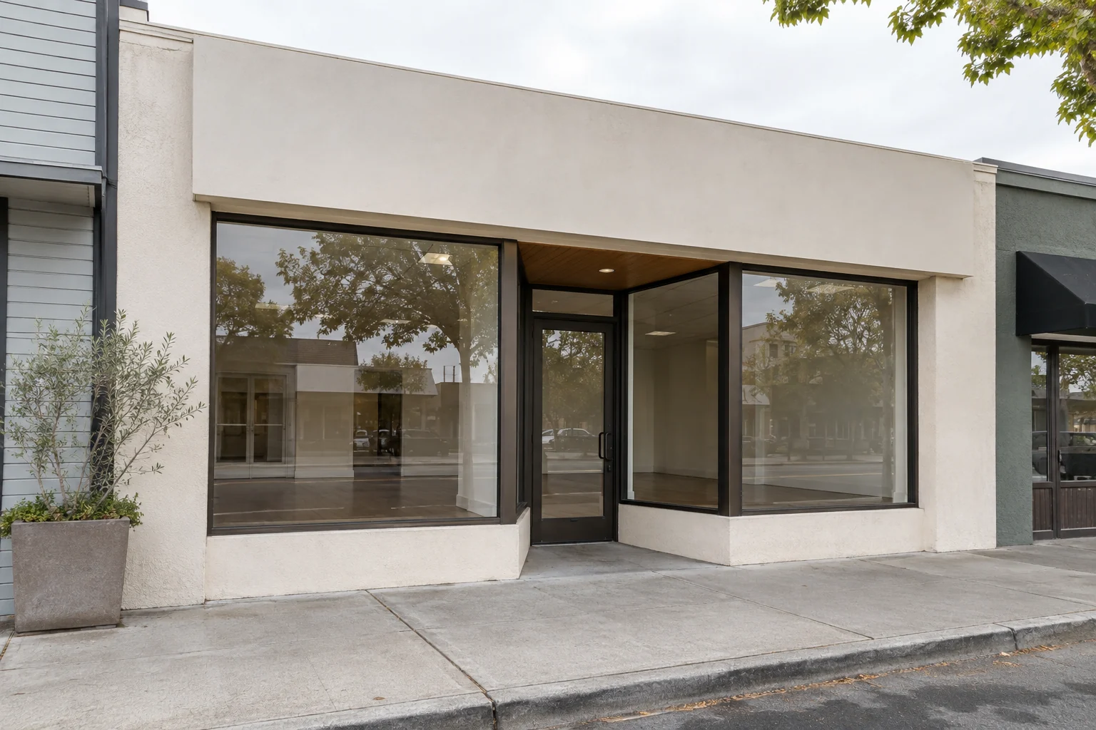 Vacant retail storefront with large display windows and a recessed glass entry
